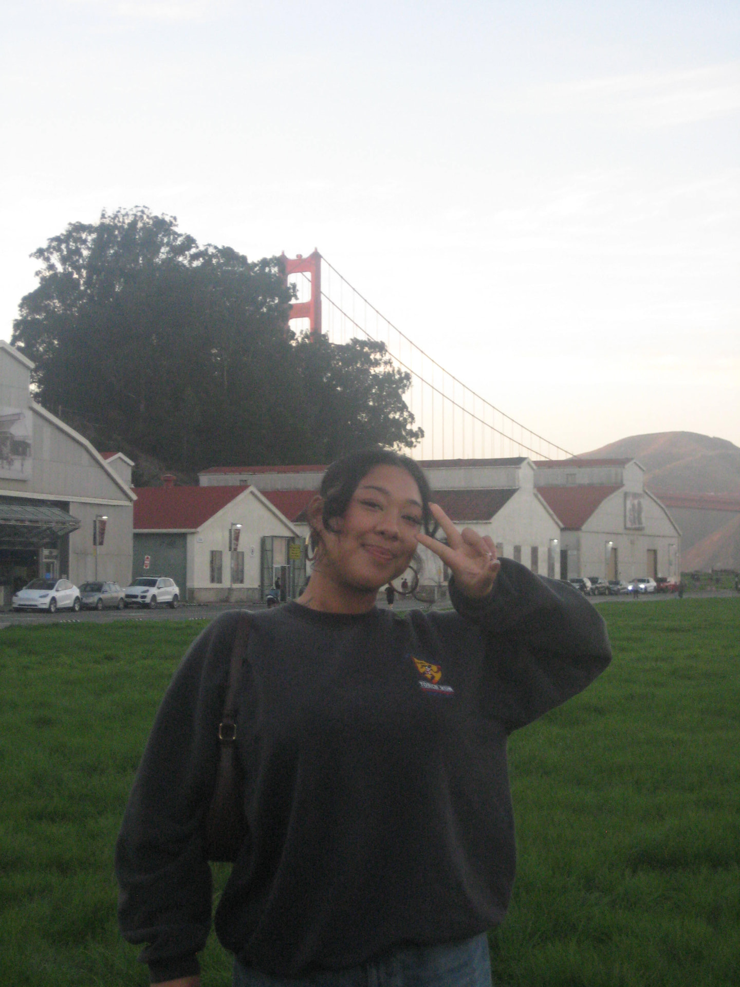 Esa Zipagan, owner of Scoop & Squish, smiling in front of the Golden Gate Bridge